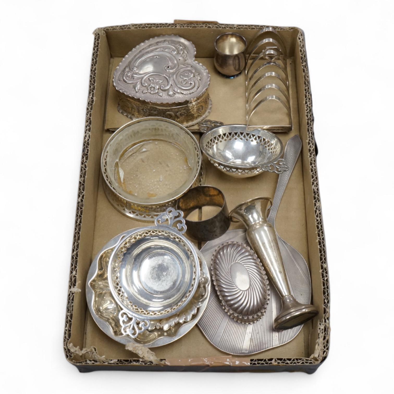 A group of small collectable silver including a late Victorian heart shaped trinket box, Chester, 1899, length 92mm (a.f.), a coaster, toast rack, spill vase, small trinket box, a pair of two handled dishes, napkin ring,